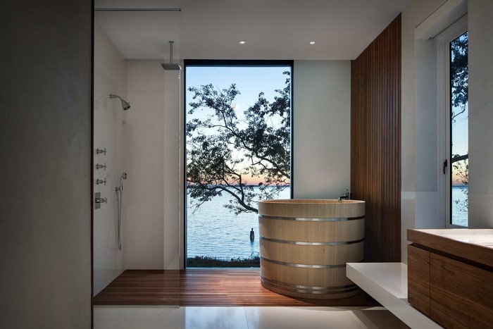 Modern bathroom with wooden tub and lake view