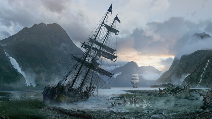 Shipwrecked sailing ship in a misty fjord with mountains