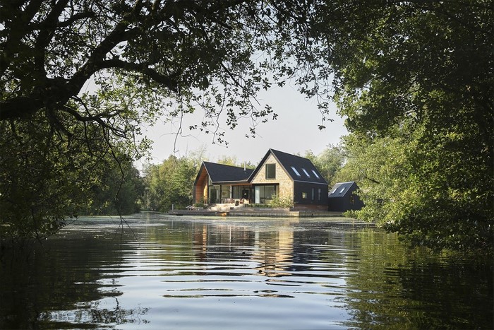 Modern house on a lake surrounded by trees