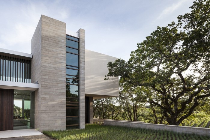 Modern concrete house with large windows and trees