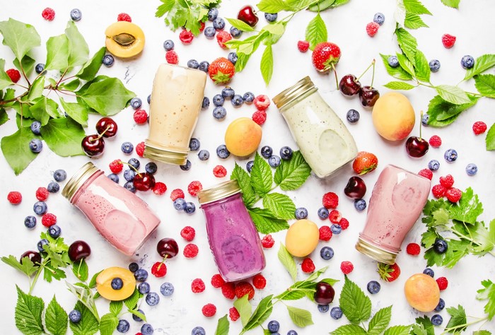 Assortment of fruit smoothies with fresh berries and apricots