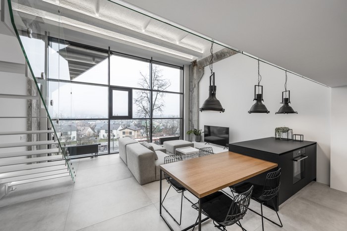Modern loft living room with large windows and dining area