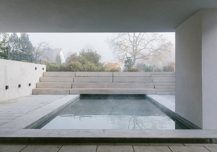Modern outdoor spa with tiered concrete steps and pool