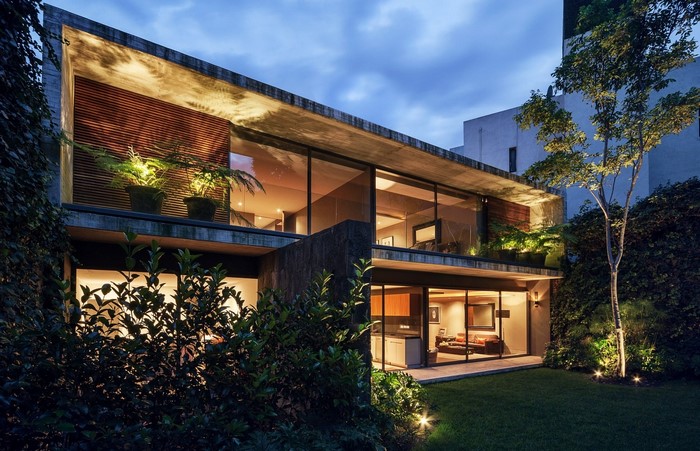 Modern concrete house with large windows and garden