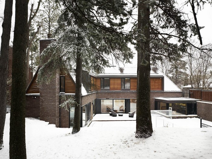 Modern house with brick and wood exterior in a snowy forest
