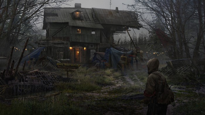 Man in hooded jacket in front of a dilapidated wooden house