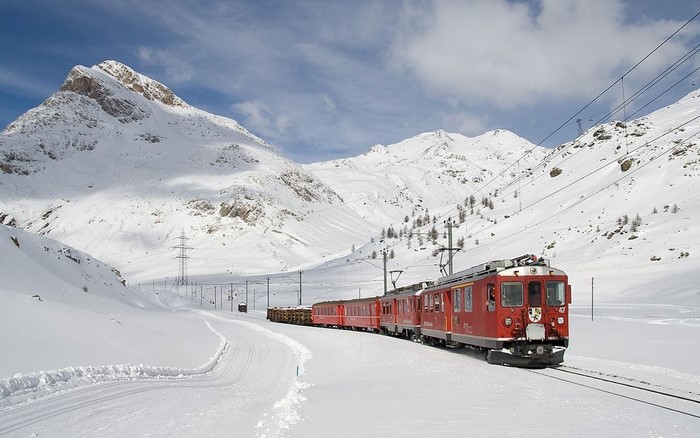 Red train in snowy mountains