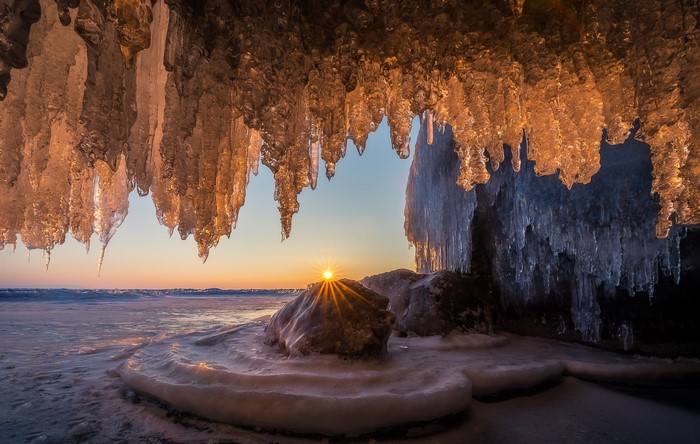 Icicles and sunset over a frozen landscape