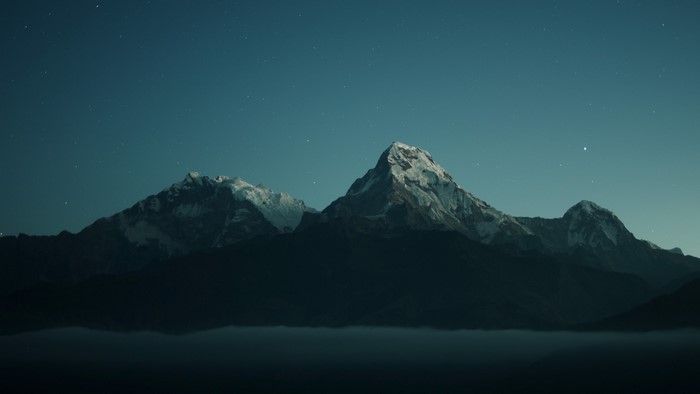 Snowy mountains under a starry night sky