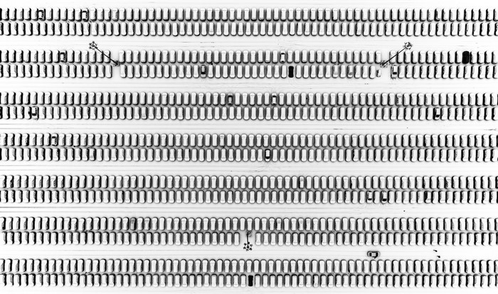 Aerial view of a snow-covered parking lot with cars