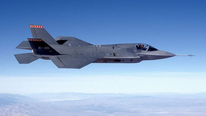 X-35 aircraft in flight over mountains