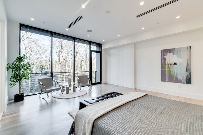 Modern bedroom with large windows and abstract art