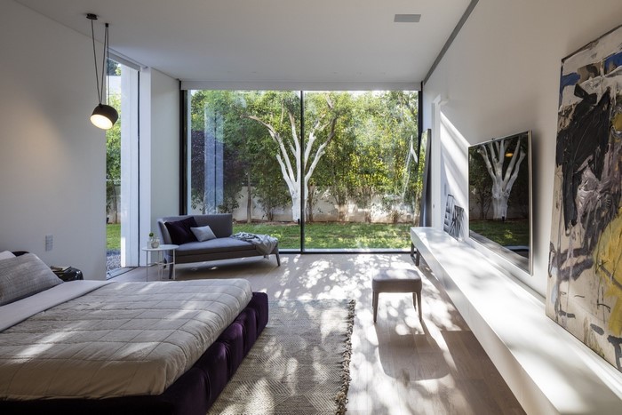Modern bedroom with large window overlooking a garden