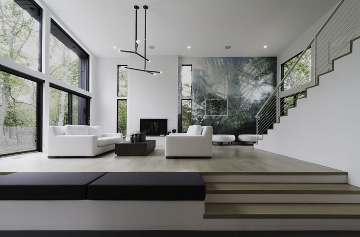 Modern living room with large windows and forest mural