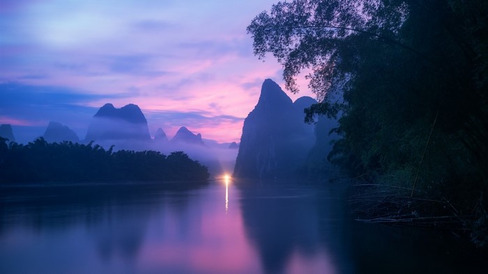 Misty mountains and river at sunrise in China