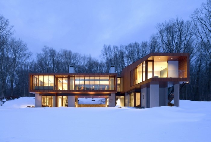 Modern house in snow with trees