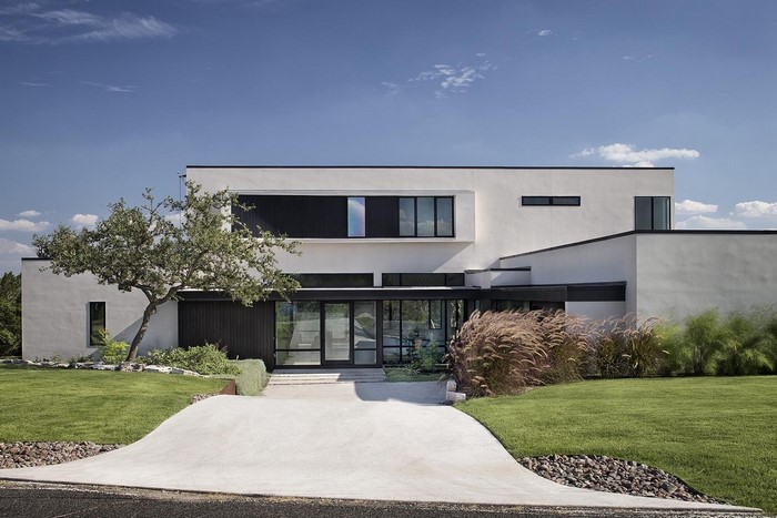 Modern white stucco house with large windows and landscaping