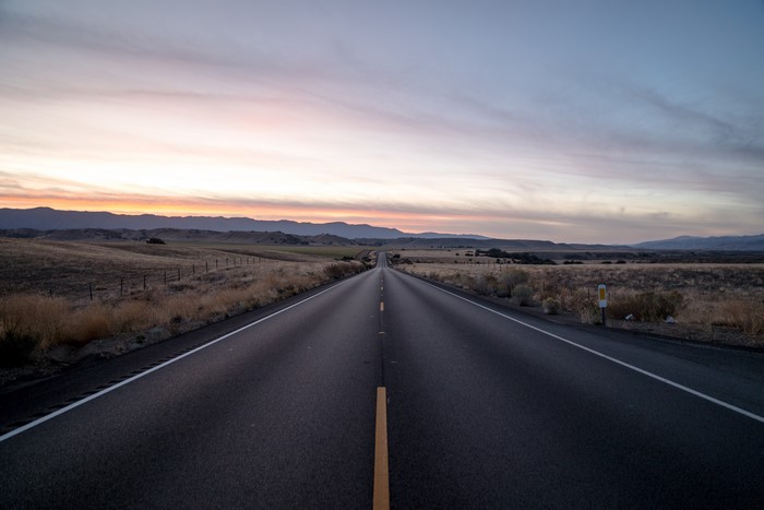 4K road through plains at sunrise