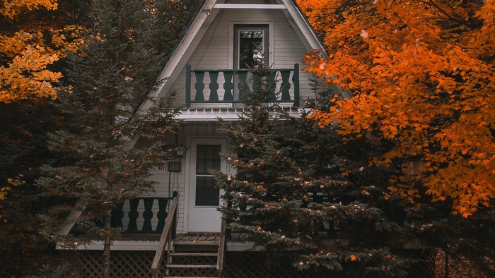 A-frame cottage surrounded by autumn trees