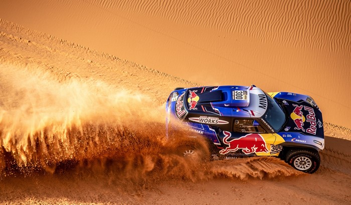 Red Bull MINI rally car racing through desert sand