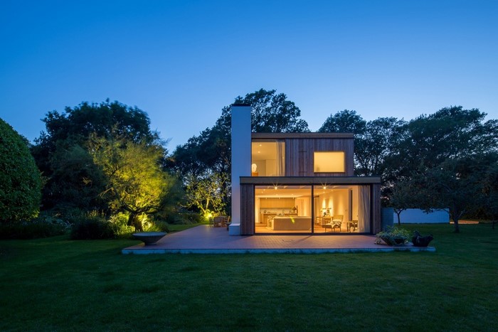 Modern wooden house with large windows at dusk