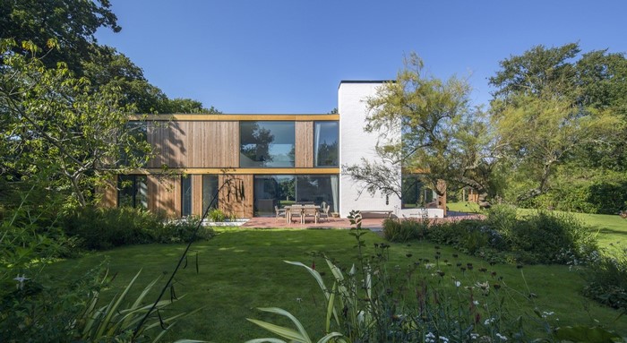 Modern wooden and white brick house with garden