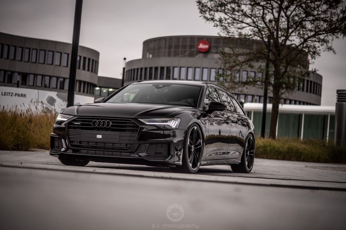 Black Audi A6 Avant in front of Leica building