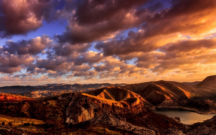 Mountainous Landscape with Dramatic Sunset Clouds and Lake