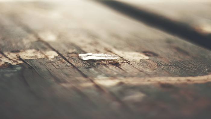 Close-up of a shard of glass on a wooden surface