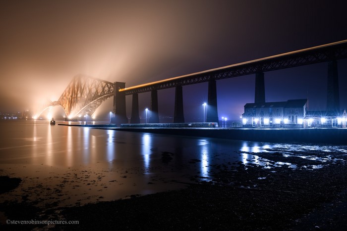 Forth Bridge at night in mist with reflections