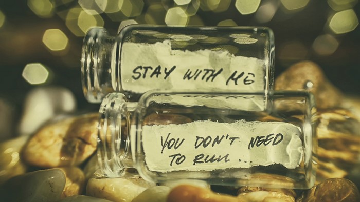 Two glass jars with handwritten notes on stones