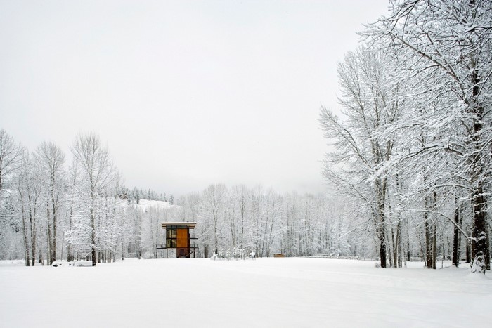 Modern house in a snowy landscape with mist
