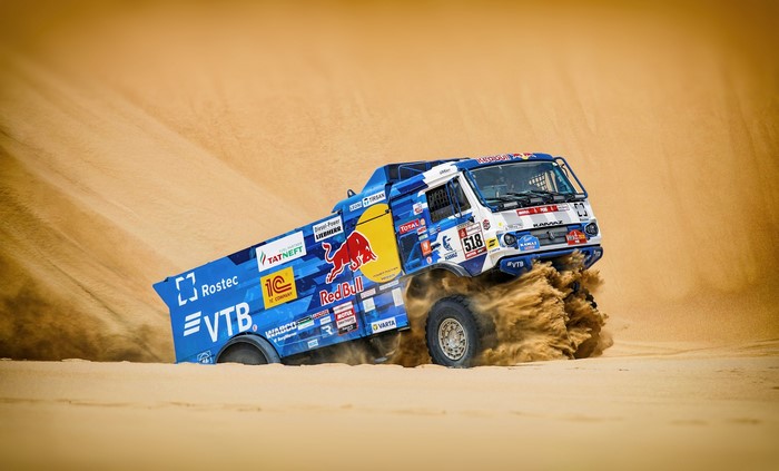 Kamaz truck racing through sand dunes