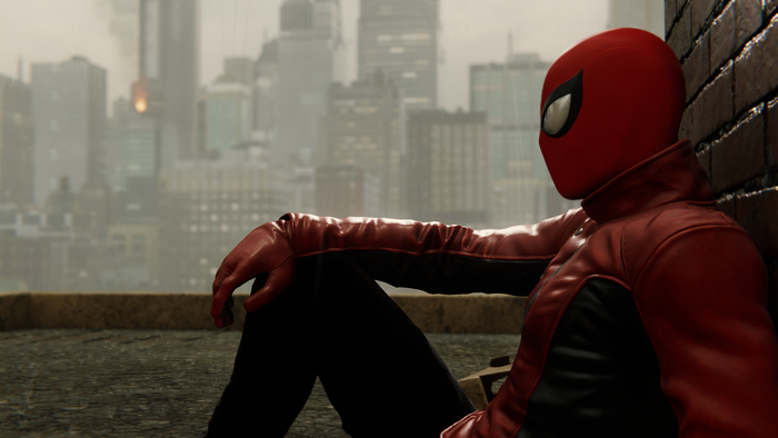 Spider-Man sitting on a rooftop in a city