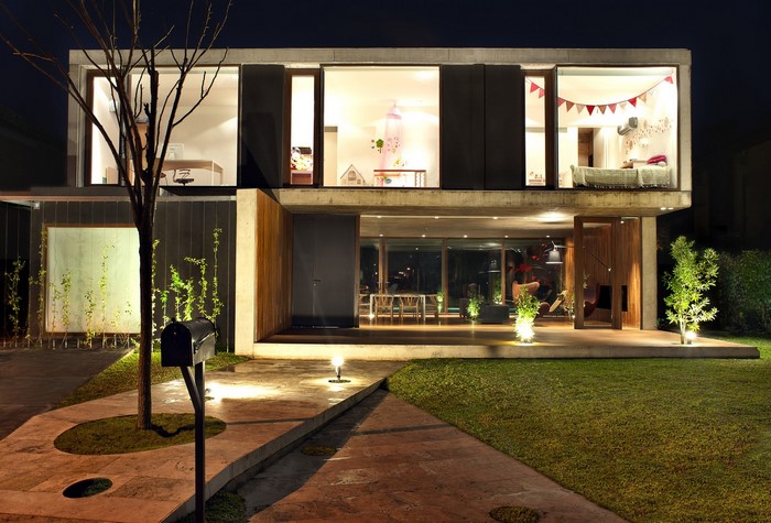 Modern concrete house at night with illuminated interior