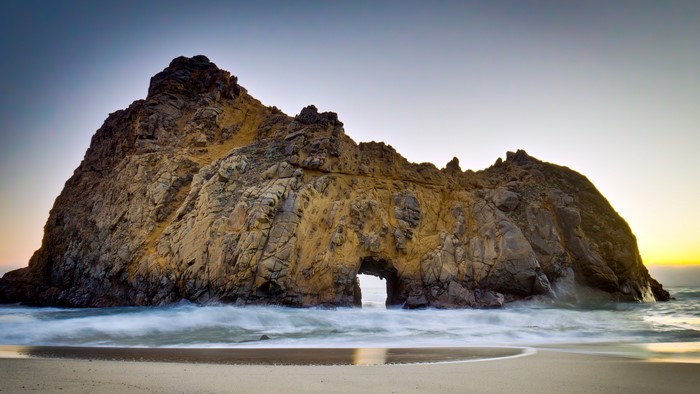 Rock formation with archway on a beach