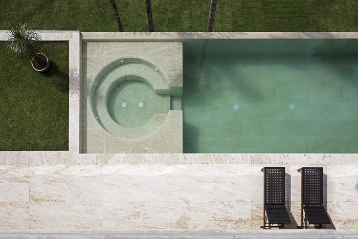 Modern swimming pool and jacuzzi with lounge chairs