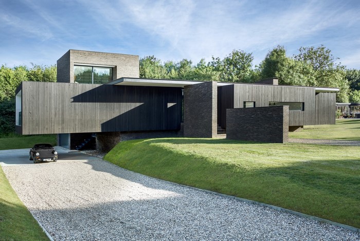 Modern house with Porsche 930 on gravel driveway