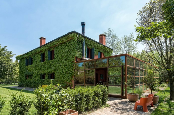Ivy-covered house with glass conservatory and garden