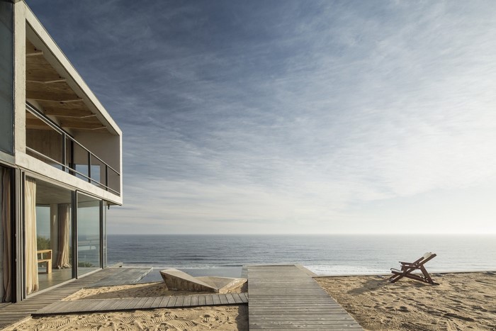 Modern concrete house on a sandy beach overlooking the sea