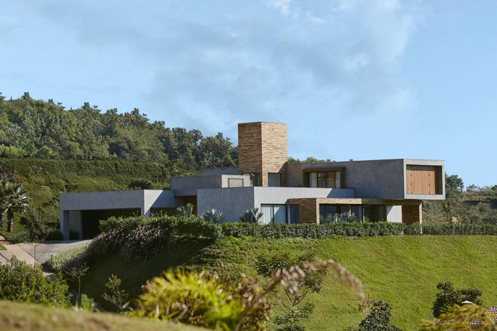 Modern concrete and stone house on a grassy hill