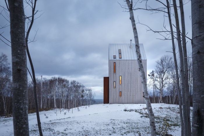 Modern wooden cabin in a snowy forest