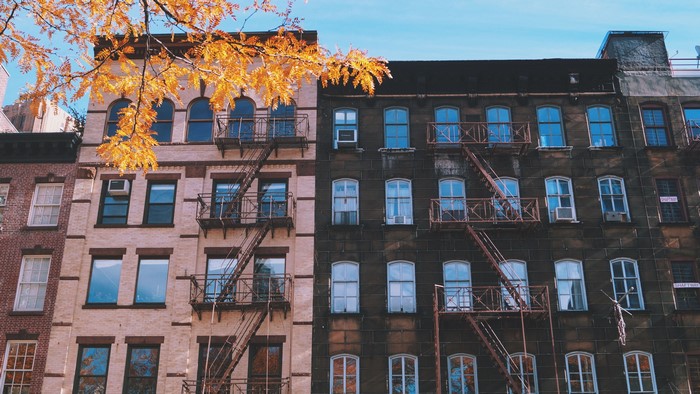 Apartment buildings with fire escapes and fall foliage