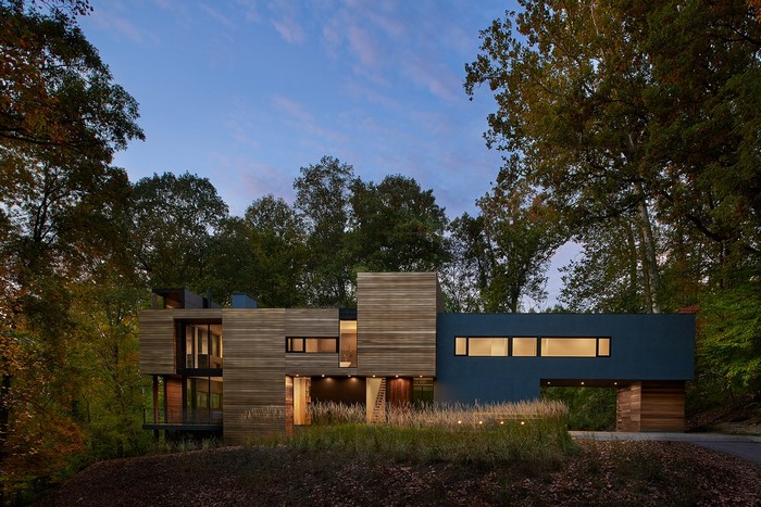 Modern wooden house in a forest at dusk