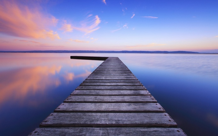 Wooden pier on a calm lake at sunset