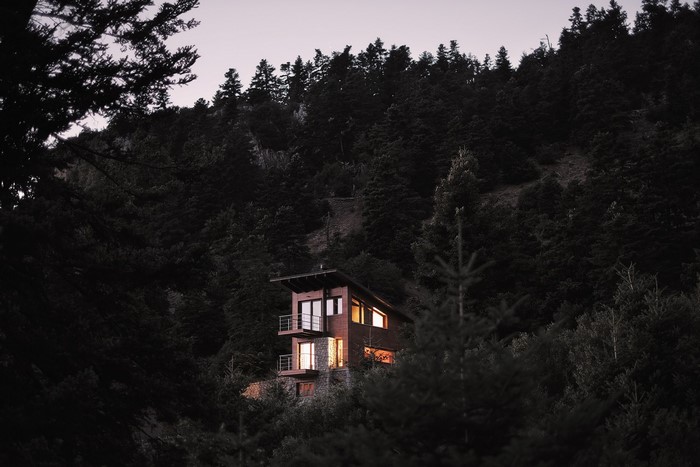 Modern house in a dark forest at dusk