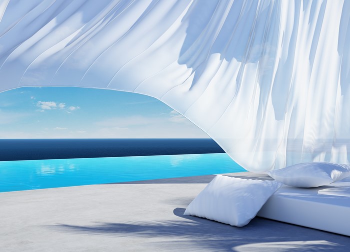 White curtains blowing in the wind by a pool