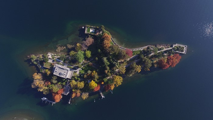 Aerial view of an island with buildings and trees in a lake