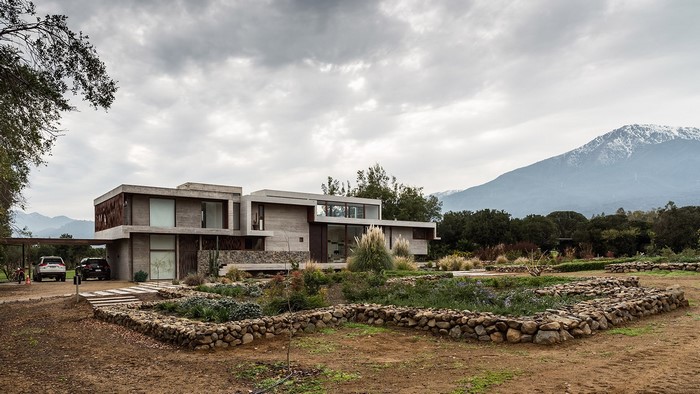 Modern concrete house with garden and mountains