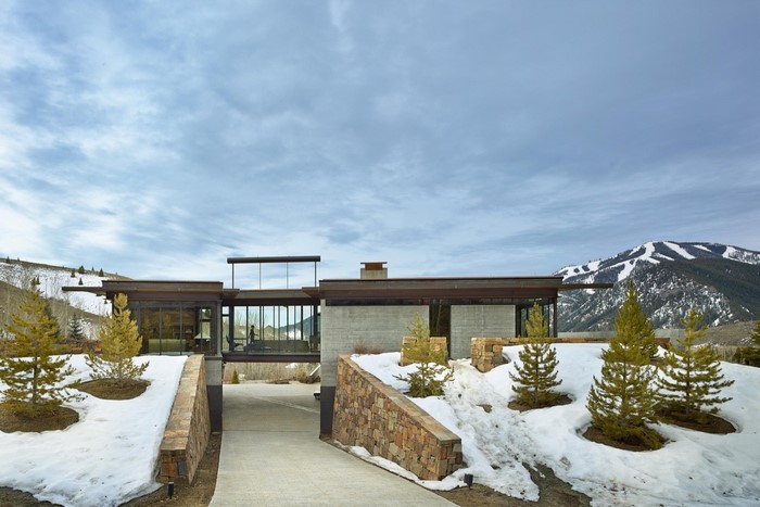 Modern luxury house with snow-capped mountains in the background